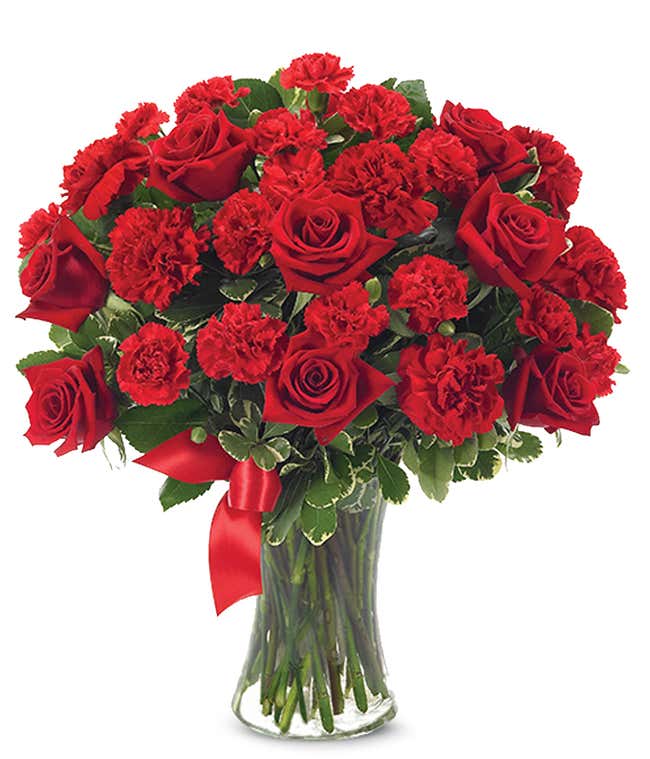 Red roses and carnations in glass vase 